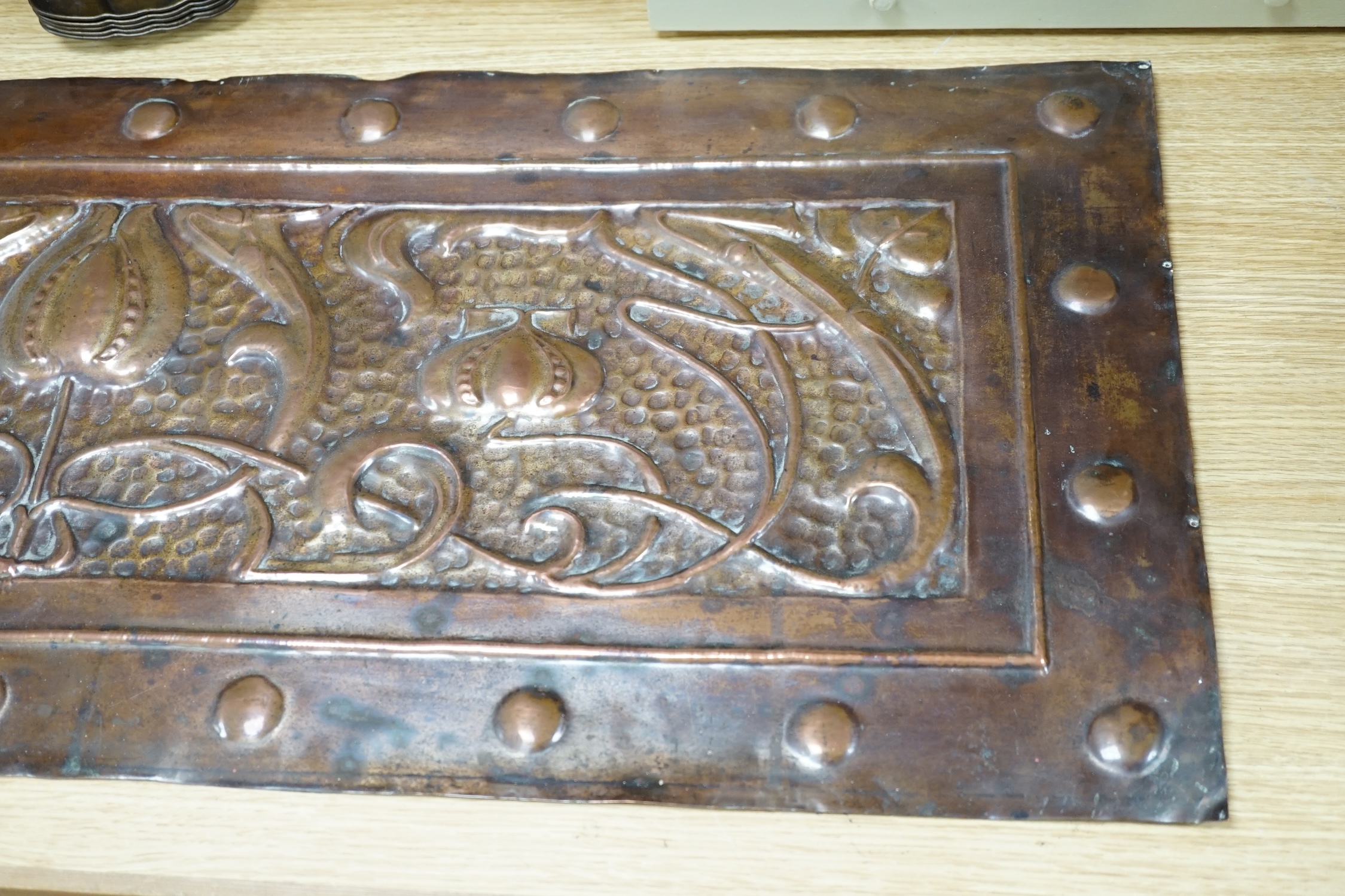 An Art Nouveau copper panel, embossed with stylised flowers and roundels, 39 x 99cm. Condition - fair